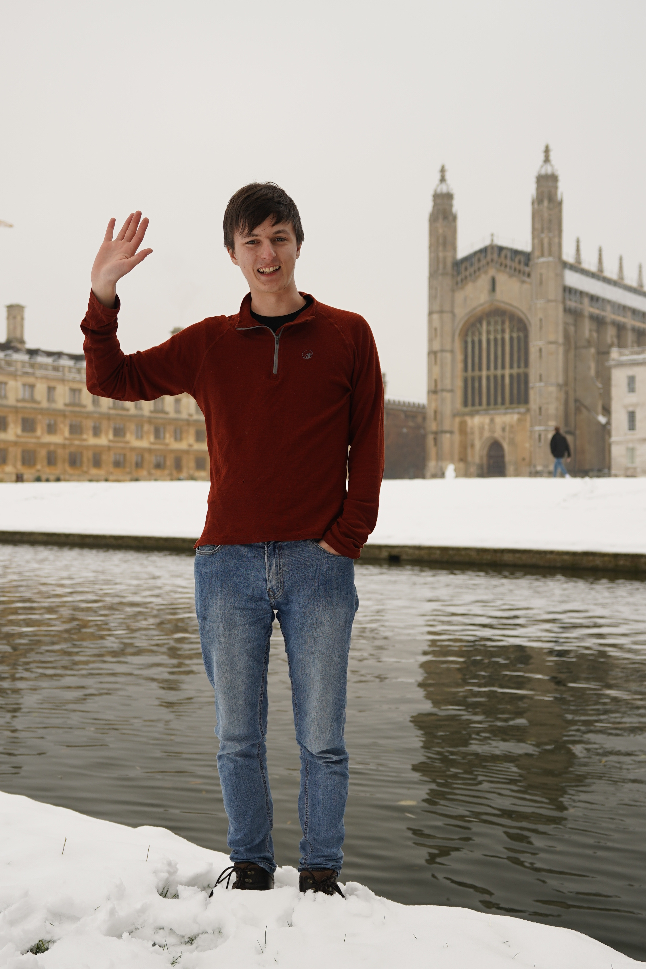 Daniel Larby waving in front of King's College Cambridge, in the snow